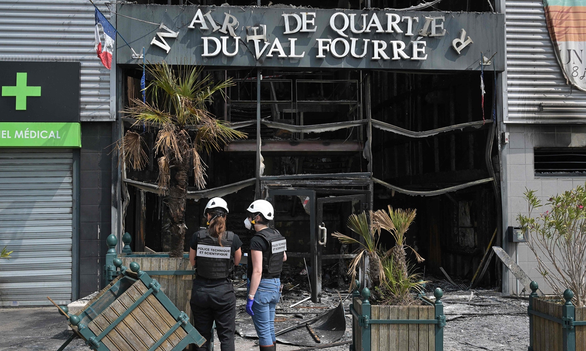 French technical and scientific police officers examine the facade of a burnt-down annex town hall of the Le Val Fourre neighborhood in Mantes-la-Jolie on June 28, 2023, a day after French police killed a 17-year-old teenager who refused to stop for a traffic check in the city. The event has prompted violent protests in west Paris. An officer has been detained and is under investigation for voluntary manslaughter. Photo: VCG