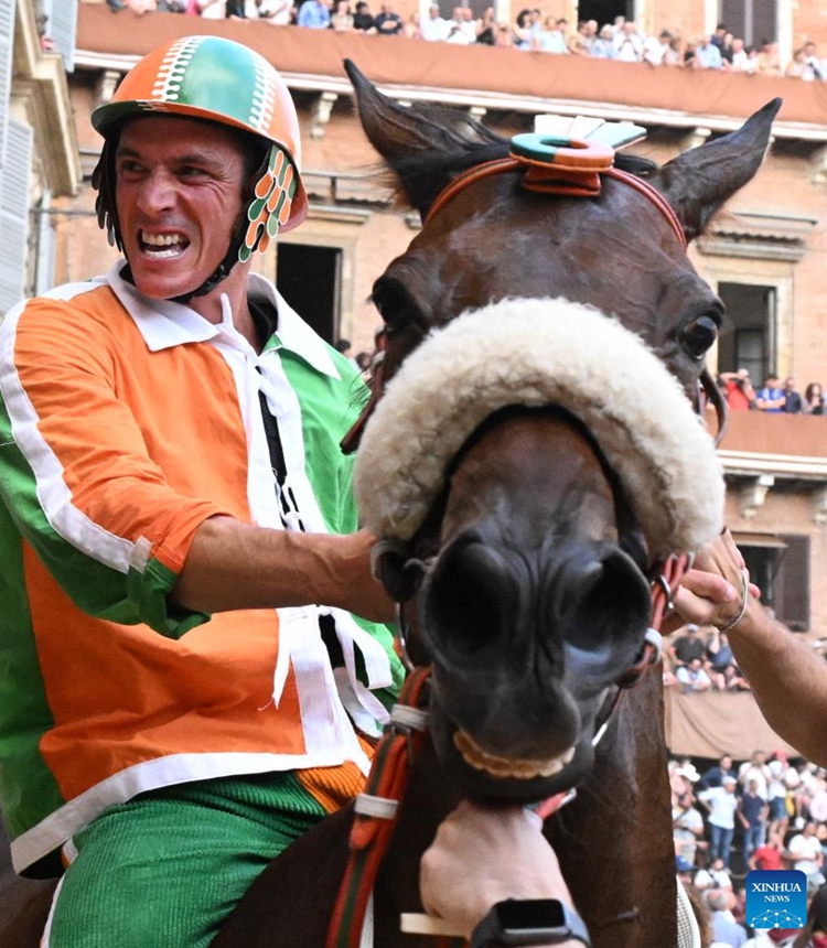 Jockey Giovanni Atzeni celebrates after winning the Palio in Siena, Italy, July 2, 2023. Palio in Siena, or Palio di Siena in Italian, is a historical horse race held twice a year in Siena since 1656. (Photo by Alberto Lingria/Xinhua)