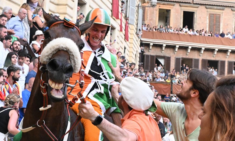 Jockey Giovanni Atzeni celebrates after winning the Palio in Siena, Italy, July 2, 2023. Palio in Siena, or Palio di Siena in Italian, is a historical horse race held twice a year in Siena since 1656. (Photo by Alberto Lingria/Xinhua)