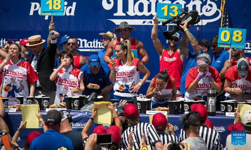 Contestants compete during a hot dog eating contest at Coney Island, New York City, the United States, on July 4, 2023. Named the Nathan's Famous Fourth of July International Hot Dog Eating Contest, the annual event has occurred each July 4 on Coney Island since 1916, according to archives. Joey Chestnut, 39, won the first place for the 16th time by eating 62 hot dogs and buns in 10 minutes.((Photo: Xinhua)