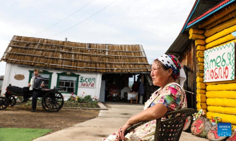 Kao Zhanhua sits in the yard in Ergun of Hulun Buir, north China's Inner Mongolia Autonomous Region, June 28, 2023. 57-year-old Kao Zhanhua of the Russian ethnic group, is a representative inheritor of Russian ethnic folk dance, an intangible cultural heritage of Hulun Buir. She has been running a homestay business in her residence with traditional Russian ethnic elements since 2004 and impressed the tourists with its specialties.(Photo: Xinhua)