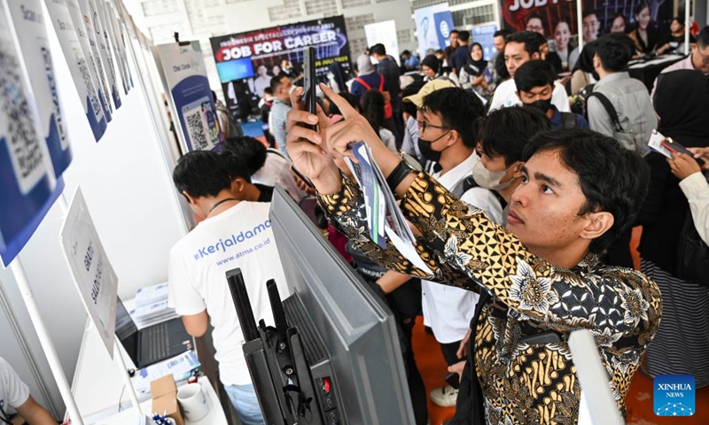 A man scans a QR code with his mobile phone for job vacancy information during a job fair at Gelora Bung Karno stadium (GBK stadium) in Jakarta, Indonesia, on July 4, 2023.((Photo: Xinhua)