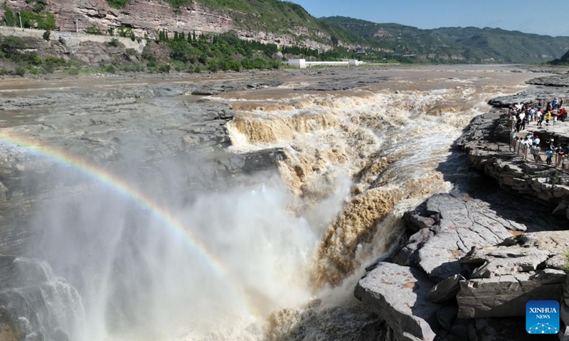 This aerial photo taken on July 3, 2023 shows tourists viewing the scenery of the Hukou Waterfall on the Yellow River, on the border area between north China's Shanxi and northwest China's Shaanxi provinces.(Photo: Xinhua)