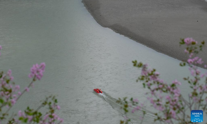 This photo taken on June 20, 2023 shows tourists riding a rubber boat in Shigu Town of Lijiang City, southwest China's Yunnan Province. Shigu Town of Yulong County is located by a huge bend of the Jinsha River, the upper section of the Yangtze River in southwest China. The footprints of the Red Army are forever engraved in the town's culture and spirits.(Photo: Xinhua)