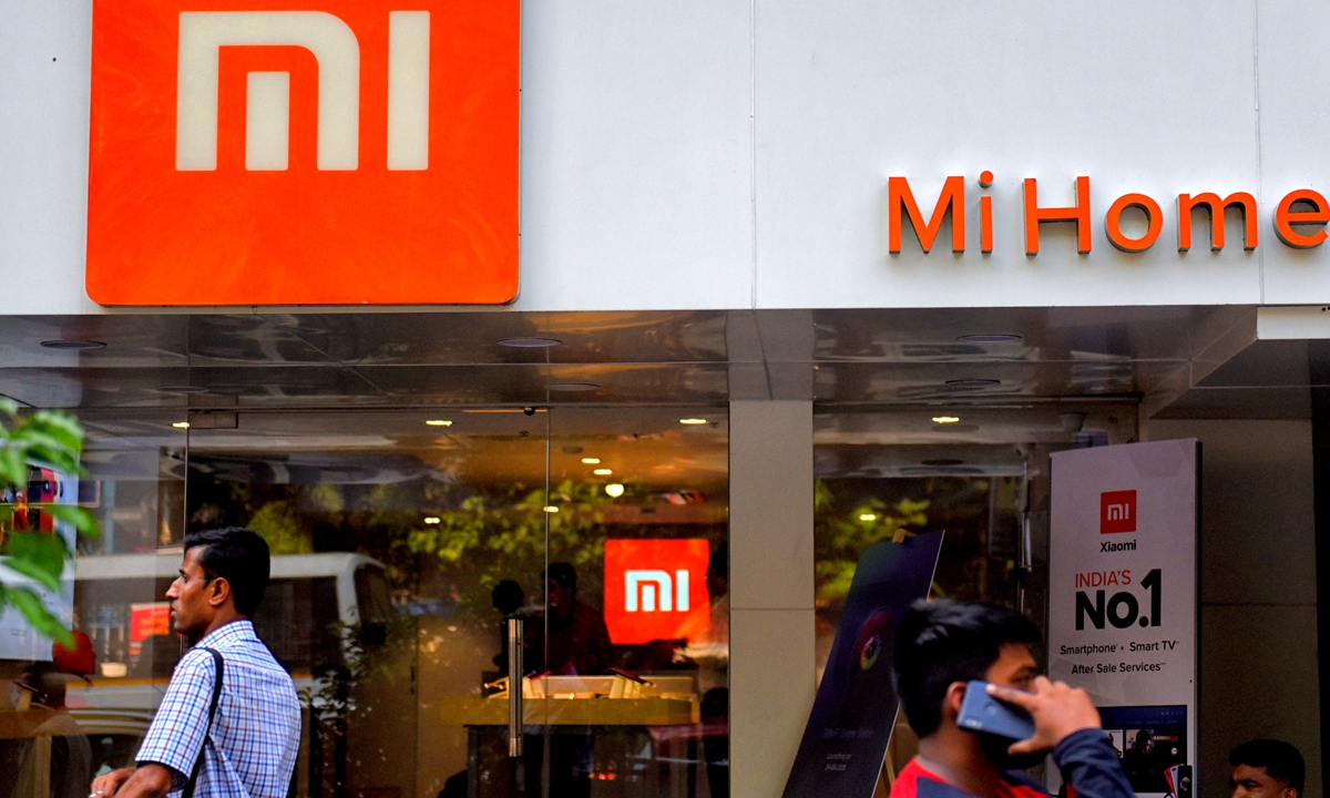 Pedestrians walk past a MI home mobile store in India, on April 22, 2019. Photo: VCG