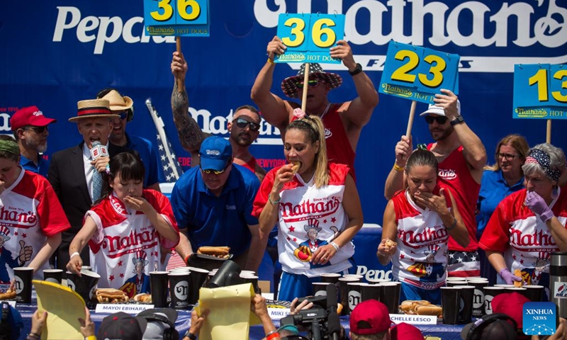 Contestants compete during a hot dog eating contest at Coney Island, New York City, the United States, on July 4, 2023. Named the Nathan's Famous Fourth of July International Hot Dog Eating Contest, the annual event has occurred each July 4 on Coney Island since 1916, according to archives.((Photo: Xinhua)