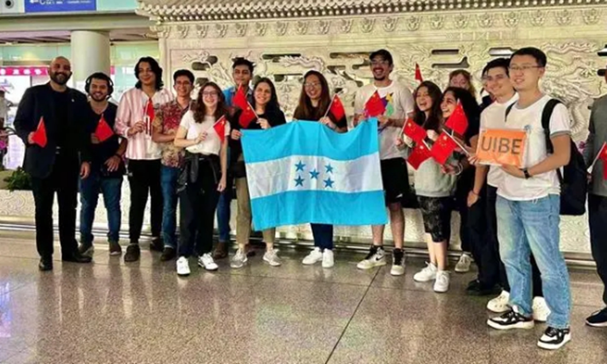 Honduran students who have arrived at the Beijing Capital International Airport pose for a group photo, holding national flags of Honduras and China, on July 4, 2023. Photo: CCTV