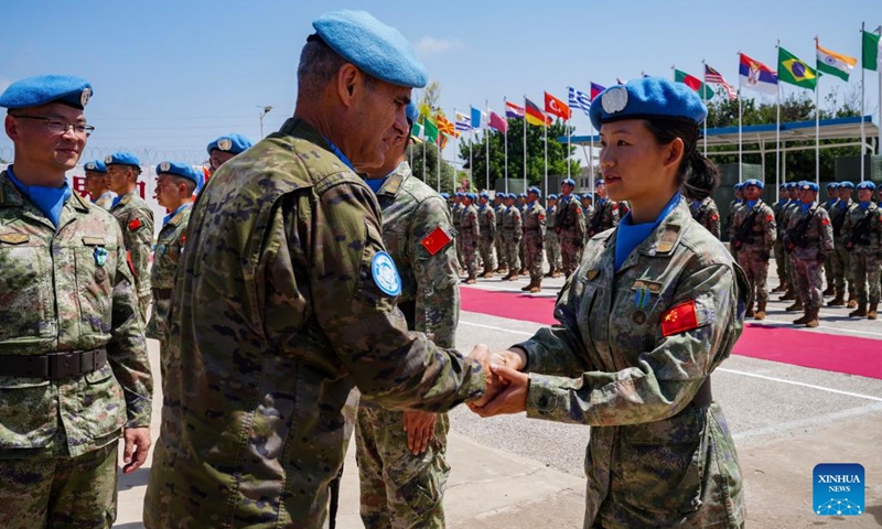 Aroldo Lazaro Saenz (L, front), commander of the UN Interim Force in Lebanon (UNIFIL), shakes hands with a member of the 21st Chinese peacekeeping contingent at the camp of the contigent in Hanniyah village in southern Lebanon, on July 4, 2023. A total of 410 peacekeepers of the 21st Chinese peacekeeping contingent to Lebanon were awarded UN medals of peace on Tuesday for their outstanding commitment to maintaining stability and peace in the south of the country.(Photo: Xinhua)