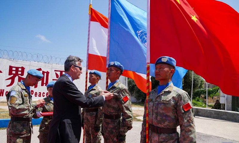 An official of the UN Interim Force in Lebanon (UNIFIL) presents a UN medal of peace to a member of the 21st Chinese peacekeeping contingent at the camp of the contigent in Hanniyah village in southern Lebanon, on July 4, 2023. A total of 410 peacekeepers of the 21st Chinese peacekeeping contingent to Lebanon were awarded UN medals of peace on Tuesday for their outstanding commitment to maintaining stability and peace in the south of the country.(Photo: Xinhua)