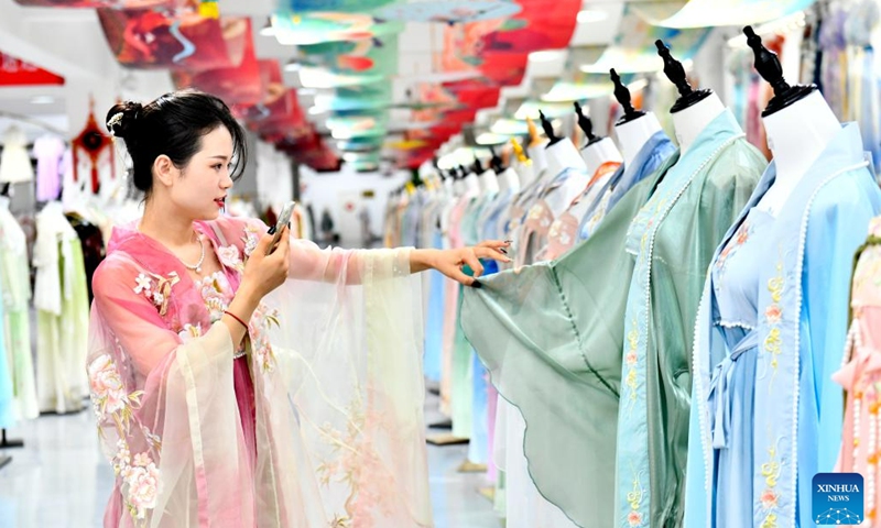 A woman promotes traditional Chinese Hanfu clothing via livestreaming at a Hanfu base in Caoxian County, east China's Shandong Province, July 6, 2023. Caoxian County has developed a complete Hanfu industrial chain in recent years. At present, there are more than 2,100 Hanfu-related enterprises in the county. The sales of Hanfu in Caoxian reached nearly 4 billion yuan (about 552 million U.S. dollars) in the first half of this year.(Photo: Xinhua)