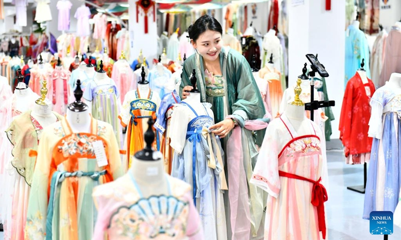 A woman promotes traditional Chinese Hanfu clothing via livestreaming at a Hanfu base in Caoxian County, east China's Shandong Province, July 6, 2023. Caoxian County has developed a complete Hanfu industrial chain in recent years. At present, there are more than 2,100 Hanfu-related enterprises in the county. The sales of Hanfu in Caoxian reached nearly 4 billion yuan (about 552 million U.S. dollars) in the first half of this year.(Photo: Xinhua)