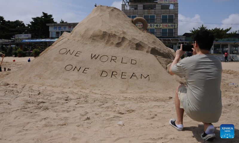 A man takes pictures of a sand sculpture during a sand sculpture festival on Yeonpo Beach in Taean County, South Chungcheong Province, South Korea, July 8, 2023. (Xinhua/Zhou Siyu)