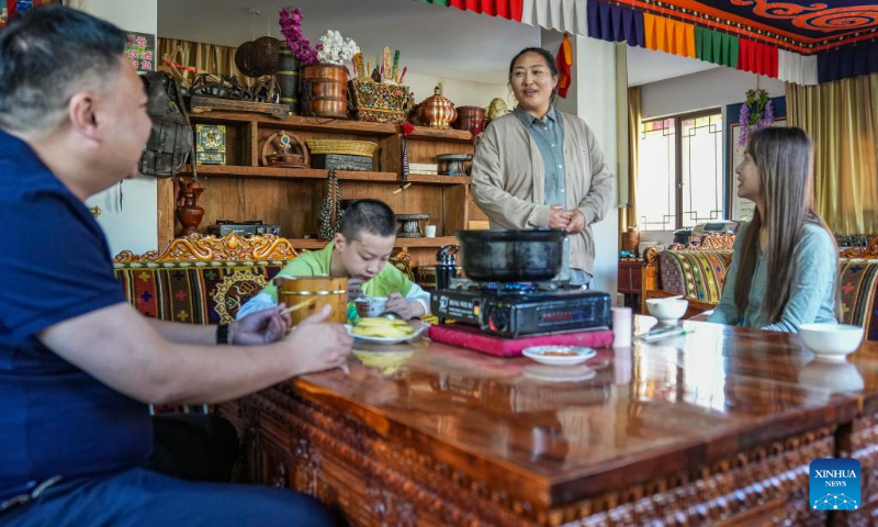 Cering Degyi (2nd R) talks to a tourist at a homestay in Gaiba Village of Gongbo'Gyamda County in Nyingchi City, southwest China's Tibet Autonomous Region, July 19, 2023. (Xinhua/Sun Fei)