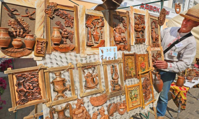 A vendor shows artworks of pottery during the 32nd International Festival of Arts Slavianski Bazaar in Vitebsk, Belarus, July 14, 2023. (Photo by Henadz Zhinkov/Xinhua)