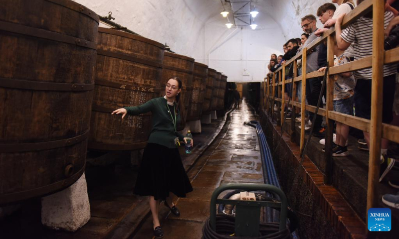 A tour guide (L) introduces Pilsner Urquell brewery to visitors in Pilsen, the Czech Republic, July 22, 2023. (Xinhua/He Canling)