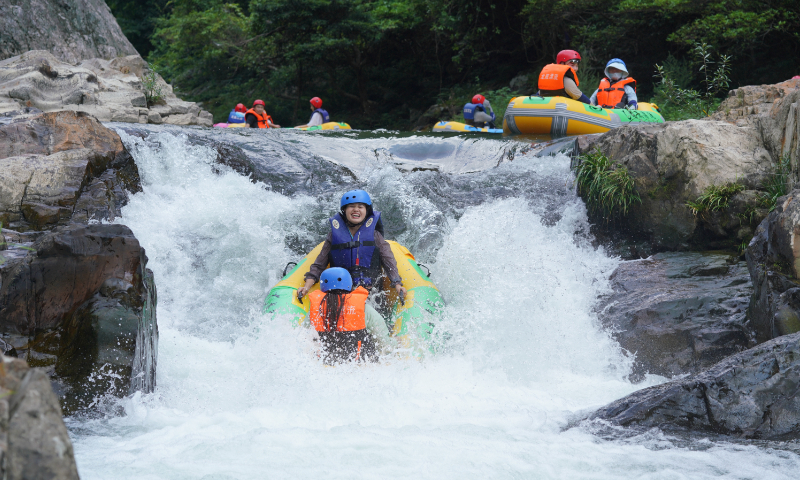 Tourists drift in the Longdi River in Wanfo township, Central China's Hunan Province, on July 23, 2023. The forest coverage rate of the Longdi rafting scenic area has reached 97 percent. The length of the drifting river is 10 kilometers. As the temperature continues to rise, rafting and camping in the mountains have been trending. Photo: VCG