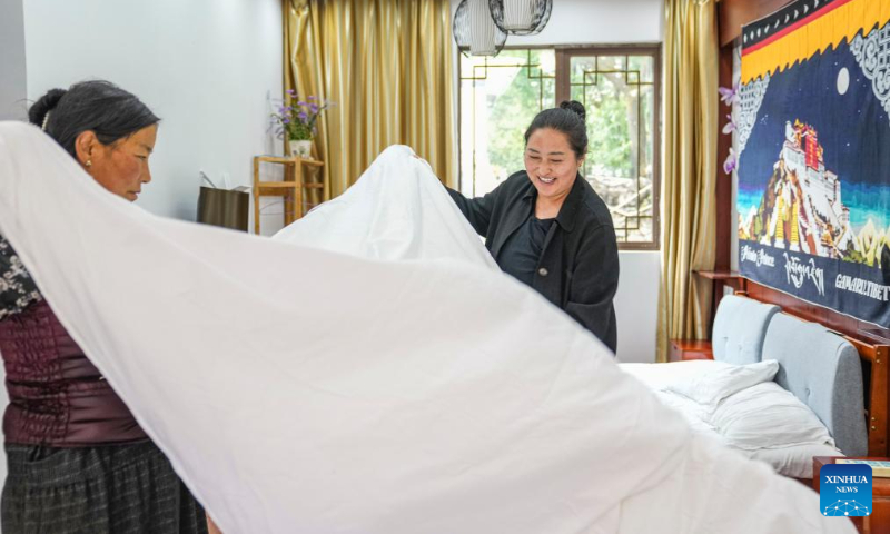 Cering Degyi (R) cleans a room with her sister at a homestay in Gaiba Village of Gongbo'Gyamda County in Nyingchi City, southwest China's Tibet Autonomous Region, July 20, 2023. (Xinhua/Sun Fei)