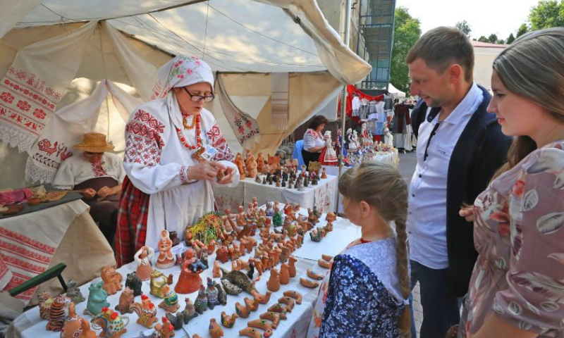 Customers select pottery products during the 32nd International Festival of Arts Slavianski Bazaar in Vitebsk, Belarus, July 14, 2023. (Photo by Henadz Zhinkov/Xinhua)