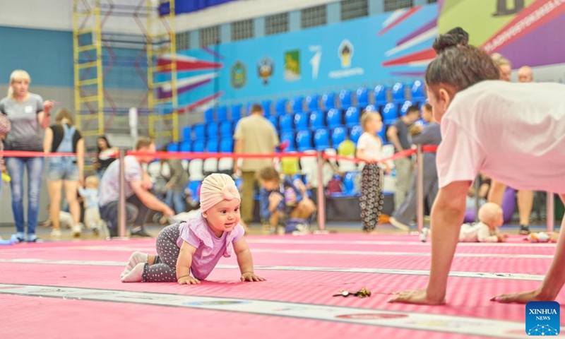 A baby takes part in a baby crawling race in Vladivostok, Russia, July 8, 2023. July 8 marks the Day of Family, Love and Fidelity in Russia. A baby crawling race was held in Russia's Far East city of Vladivostok to celebrate the occasion. (Photo by Guo Feizhou/Xinhua)