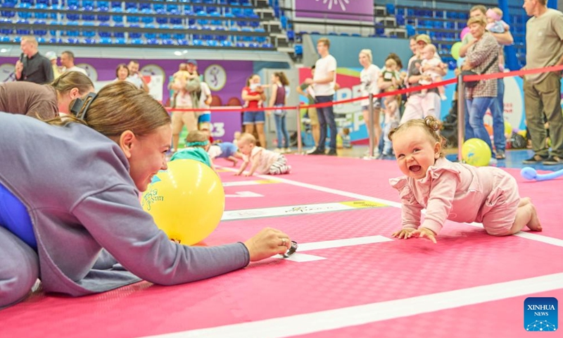 Babies and their parents take part in a baby crawling race in Vladivostok, Russia, July 8, 2023. July 8 marks the Day of Family, Love and Fidelity in Russia. A baby crawling race was held in Russia's Far East city of Vladivostok to celebrate the occasion. (Photo by Guo Feizhou/Xinhua)