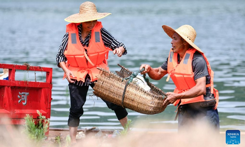 Lu Xiyong and Ran Maoying clean up floating garbage on the Wujiang River in Zhucang Township of Weng'an County, southwest China's Guizhou Province, July 11, 2023. Lu and Ran are local villagers who grew up along the Wujiang River and got married in 1986. For decades, the couple took the initiative to clean up the floating garbage along the Wujiang River and promote environmental protection while working on ferries.(Photo: Xinhua)