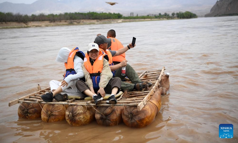 Tourists experience sheepskin rafting at the Yellow River Stone Forest Scenic Spot in Jingtai County of Baiyin City, northwest China's Gansu Province, July 11, 2023. Yellow River Stone Forest Scenic Spot is famous for the view of the Yellow River, stone stalagmites, stone pillars, dessert as well as oases.(Photo: Xinhua)