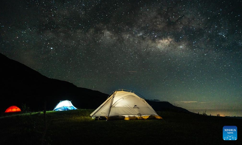 This photo taken on July 8, 2023 shows a night view of a camping site by the Nam Ngum Lake in Vientiane Province, Laos. The Nam Ngum Lake, located at the lower reaches of the Nam Ngum River, a tributary of Mekong River, is known as the thousand-island lake in Laos.(Photo: Xinhua)