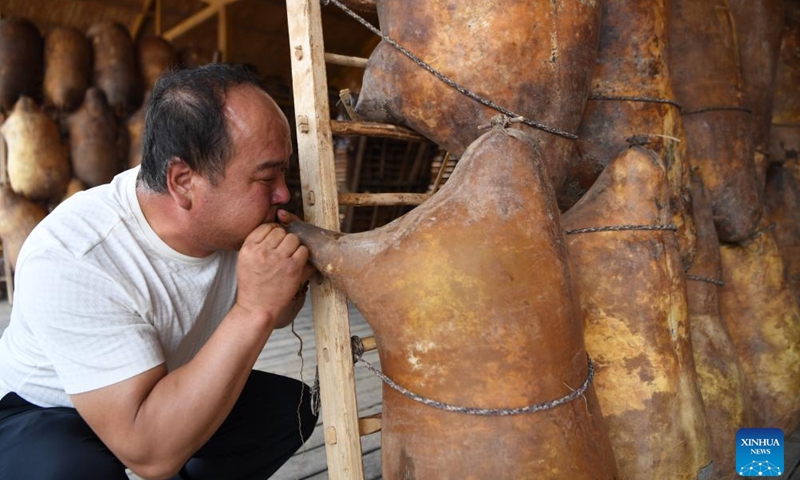 A ferry man blows a sheepskin raft as he prepares for rafting at the Yellow River Stone Forest Scenic Spot in Jingtai County of Baiyin City, northwest China's Gansu Province, July 11, 2023. Yellow River Stone Forest Scenic Spot is famous for the view of the Yellow River, stone stalagmites, stone pillars, dessert as well as oases.(Photo: Xinhua)