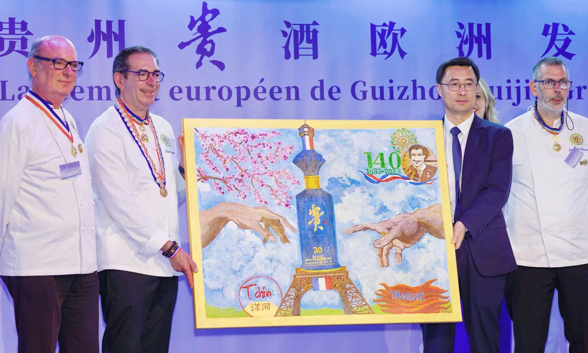 Zhang Liandong (second from right) receives a painting from Jean-Michel Framery