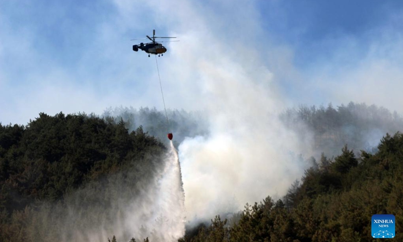 A helicopter works on containing a wildfire in Belen District of Hatay Province, Türkiye, July 17, 2023. Wildfires broke out in the southern and western provinces of Türkiye over the weekend as summer heat grips a large swathe of the country, local media reported on Monday. (Photo: Xinhua)