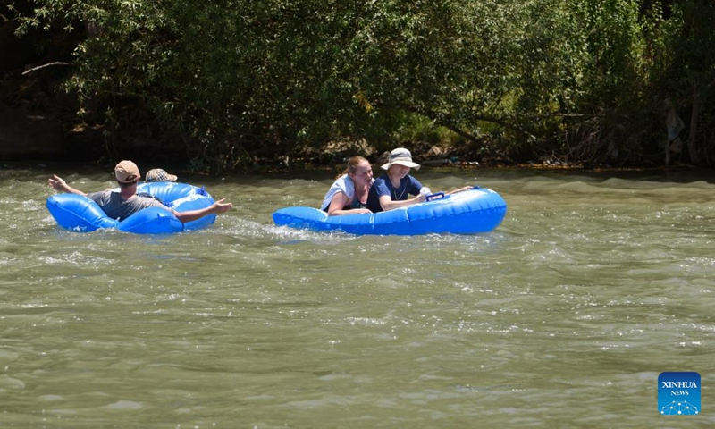 People relax themselves in the Jordan River near northern Israeli kibbutz of Kfar Blum, July 12, 2023.(Photo: Xinhua)