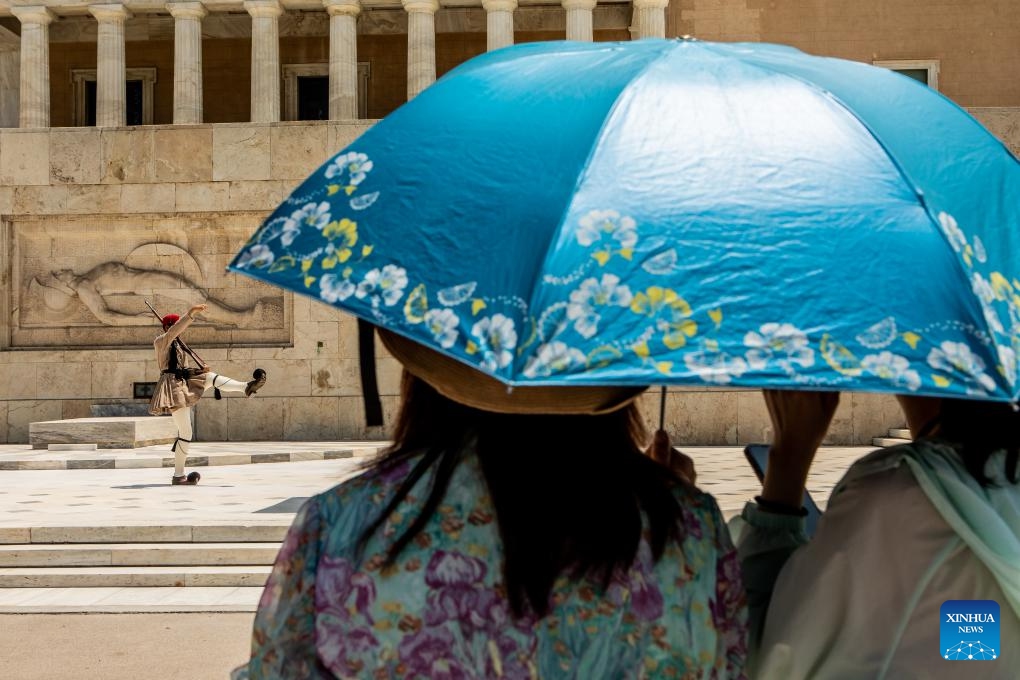 People shelter from the sun under umbrellas in Athens, Greece, July 12, 2023.(Photo: Xinhua)