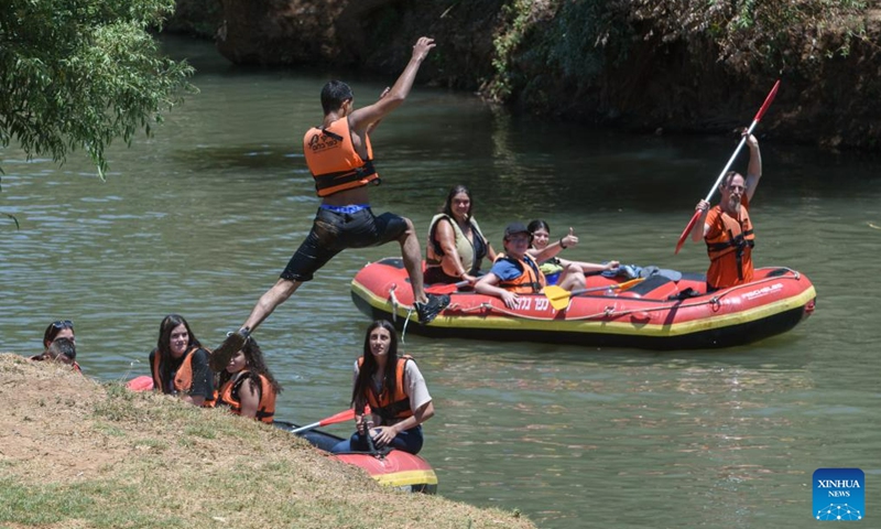 People relax themselves in the Jordan River near northern Israeli kibbutz of Kfar Blum, July 12, 2023.(Photo: Xinhua)