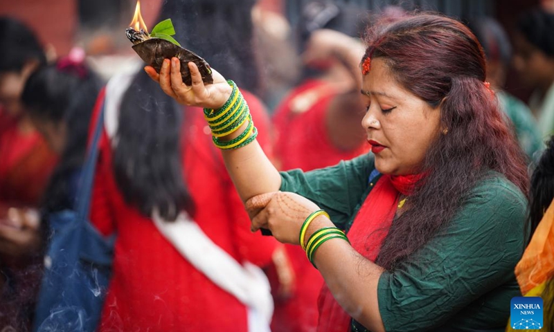 A devotee prays on the first Monday of the holy month of Shrawan in Lalitpur, Nepal, July 17, 2023. The holy month of Shrawan is considered auspicious as people offer prayers to Lord Shiva.(Photo: Xinhua)