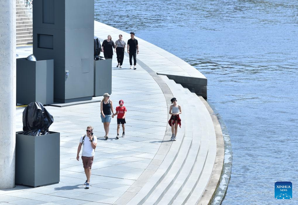 People walk by a river in Berlin, Germany, on July 13, 2023.(Photo: Xinhua)