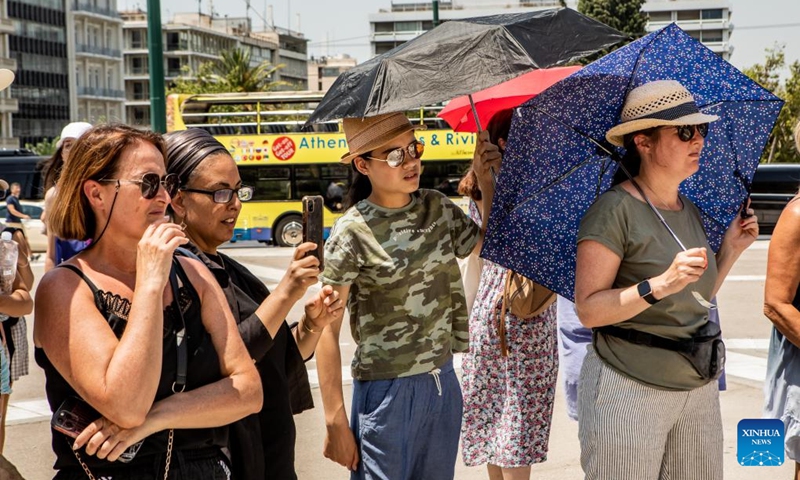 People shelter from the sun under umbrellas in Athens, Greece, July 12, 2023.(Photo: Xinhua)