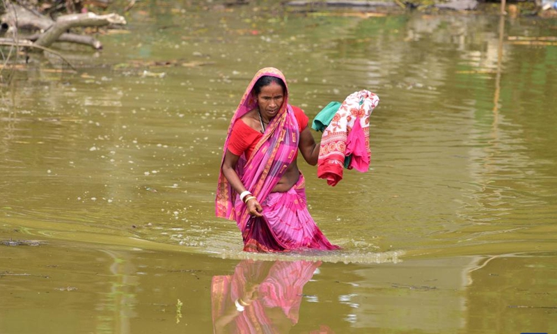 A woman wades in water at a flood-affected village in Morigaon district of India's northeastern state of Assam, July 16, 2023. (Str/Xinhua)