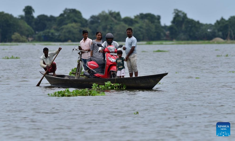 People cross a flooded area aboard a boat at a village in Morigaon district of India's northeastern state of Assam, July 16, 2023. (Str/Xinhua)