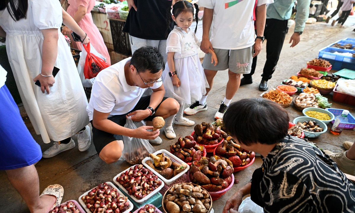 People make their purchases at an edible mushroom market in Kunming, capital of Southwest China's Yunnan Province on July 16, 2023. The province produced 316,100 tons of edible fungi in 2022, with a production value of 25 billion yuan ($3.5 billion), the Xinhua News Agency reported, citing local industry body. 