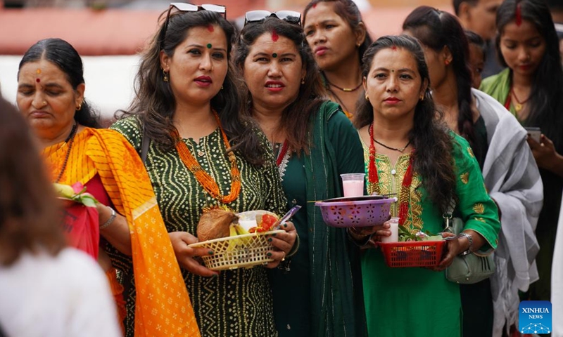 Devotees wait in line to pray on the first Monday of the holy month of Shrawan in Lalitpur, Nepal, July 17, 2023. The holy month of Shrawan is considered auspicious as people offer prayers to Lord Shiva.(Photo: Xinhua)