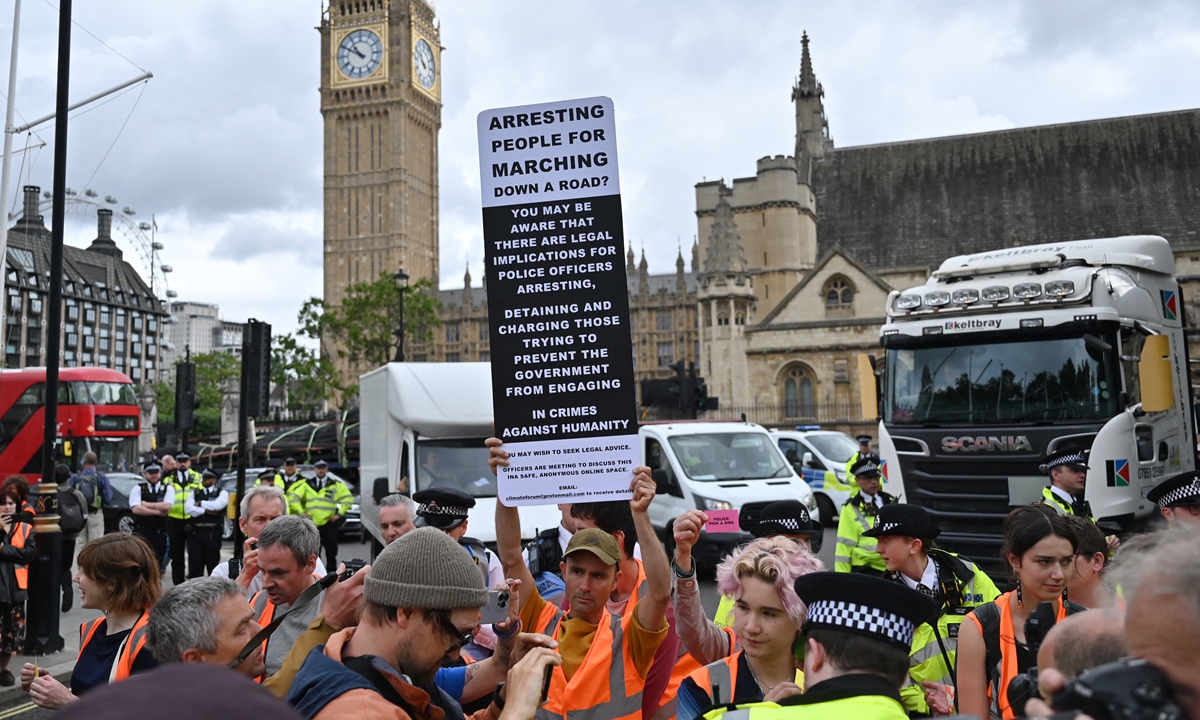 Police officers speak to Just Stop Oil climate activists marching slowly in Parliament Square in London before arrests were made on July 19, 2023. Just Stop Oil wants the British government to end all new oil and gas exploration and has promised not to let up in its protests until the government does so. Photo: VCG