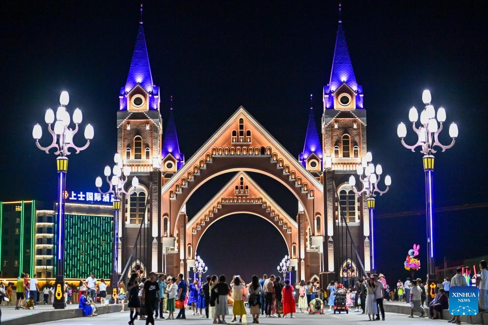 Tourists visit a bridge at Qicai river resort in Burqin County of northwest China's Xinjiang Uygur Autonomous Region, July 18, 2023. With abundant tourism resources, Burqin County has become an increasingly popular destination among travellers.(Photo: Xinhua)