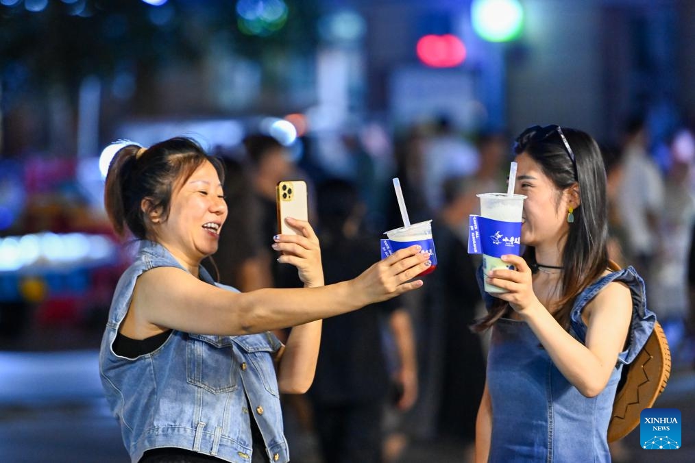 Tourists take photos at Qicai river resort in Burqin County of northwest China's Xinjiang Uygur Autonomous Region, July 18, 2023. With abundant tourism resources, Burqin County has become an increasingly popular destination among travellers.(Photo: Xinhua)