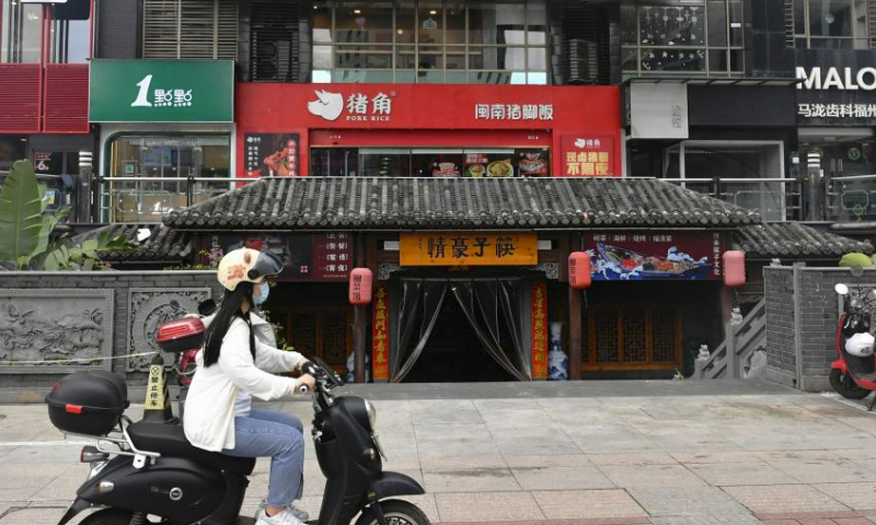 A citizen rides a scooter in a street in Fuzhou, southeast China's Fujian Province, July 30, 2023. Fuzhou has seen its urban life gradually back to normal after typhoon Doksuri swept through the city. (Xinhua/Wei Peiquan)