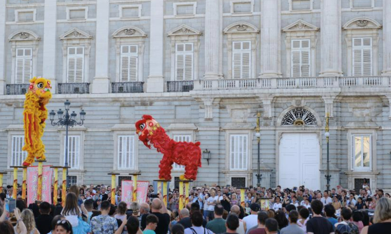 Actors perform lion dance at the Plaza de Oriente (Eastern Plaza) in Madrid, Spain, on Aug. 5, 2023. The Shenzhen Fuyong Huaide Lion Dance Troupe performed on the streets of Madrid from Friday to Sunday at the invitation of the Madrid Summer in the City Festival and the Chinese Cultural Center in Madrid. (Xinhua/Meng Dingbo)