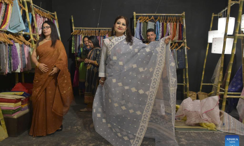 A woman tries Jamdani sarees (women's garment) during a festival in Dhaka, Bangladesh on July 29, 2023. In an attempt to restore the glorious past of Jamdani, Bangladesh has organized an 11-day festival titled Wearable Art Jamdani Festival in capital Dhaka from July 19 to highlight the textile here. (Xinhua)