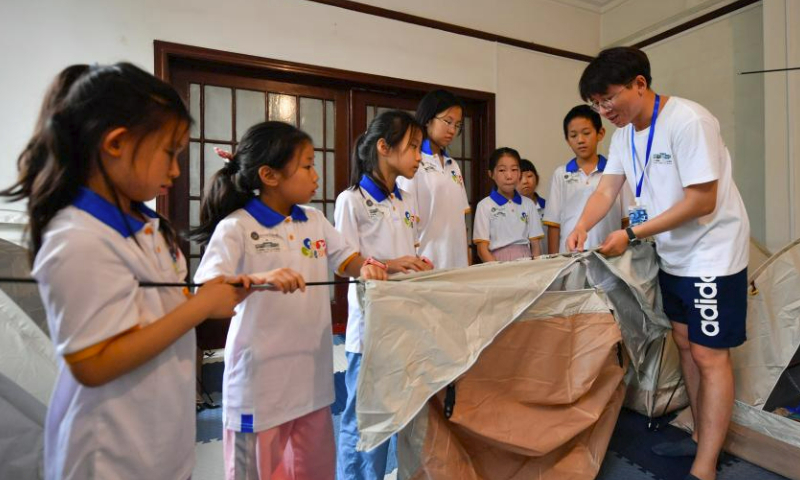 Students learn to set up a tent in the guidance of a teacher at the Tianjin Digital Art Museum in Tianjin, north China, July 30, 2023. During the summer vacation, the National Maritime Museum of China and the Tianjin Digital Art Museum jointly offered students with a study camp themed on ocean and art. Altogether 22 students from Beijing, Tianjin and Hebei Province learnt knowledge of ocean and nature and got in touch with digital art during the camp. (Xinhua/Sun Fanyue)