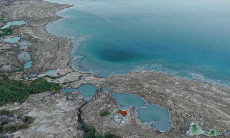 This aerial photo taken on Aug. 6, 2023 shows sinkholes on the shore of the Dead Sea near Ein Gedi beach, Israel. Statistics showed that the Dead Sea had been shrinking at an alarming pace, its water level dropping by 1.2 meters each year. As the water receded, a barren landscape of salt rock and numerous sinkholes appeared. (Photo by Gil Cohen Magen/Xinhua)