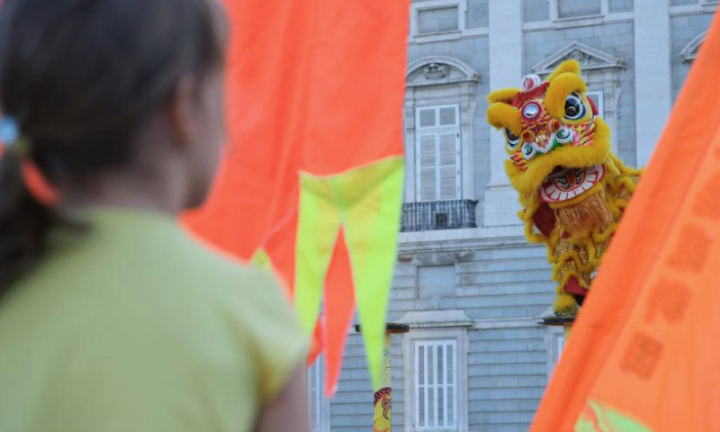 Actors perform lion dance at the Plaza de Oriente (Eastern Plaza) in Madrid, Spain, on Aug. 5, 2023. The Shenzhen Fuyong Huaide Lion Dance Troupe performed on the streets of Madrid from Friday to Sunday at the invitation of the Madrid Summer in the City Festival and the Chinese Cultural Center in Madrid. (Xinhua/Meng Dingbo)