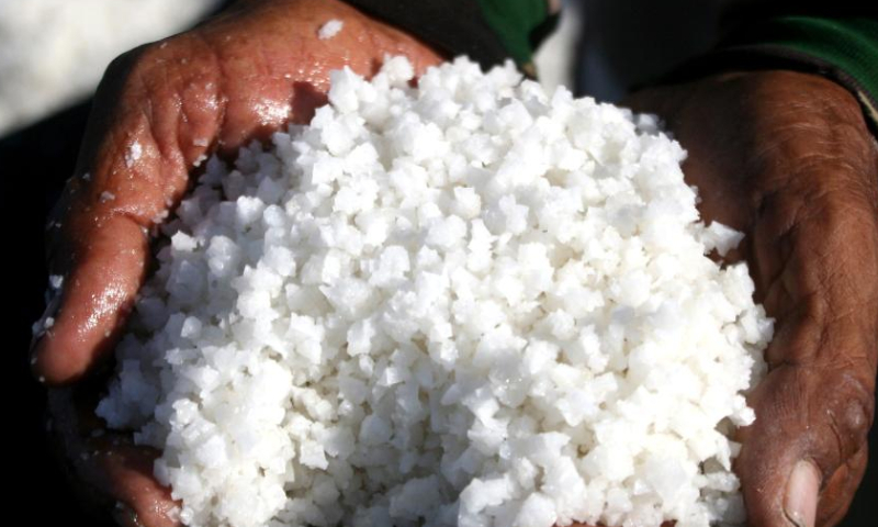 A farmer holds harvested salt in Tambak Cemandi village in Sidoarjo, East Java, Indonesia, July 31, 2023. (Photo by Sahlan Kurniawan/Xinhua)